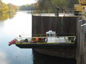 hydraulic dredge being lowered into water